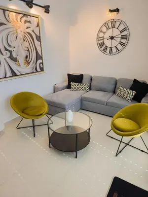 a living room with a couch and two chairs and a clock at Boulevard Apartments in Kotor