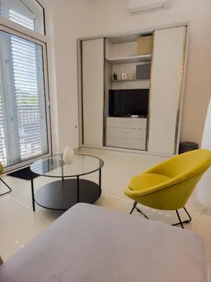 a living room with a yellow chair and a table at Boulevard Apartments in Kotor