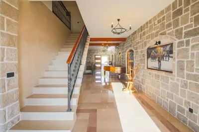 a staircase in a house with a stone wall at Villa Carevic with Indoor & Outdoor Pool in Kotor