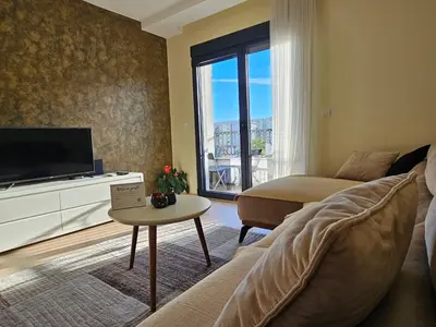 a living room with a couch and a tv at The Serendipity in Podgorica