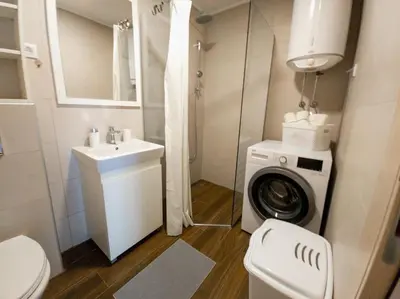 a bathroom with a washing machine and a sink at The Serendipity in Podgorica