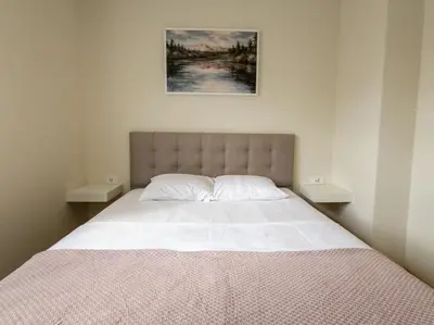 a bedroom with a large bed with two tables at The Serendipity in Podgorica