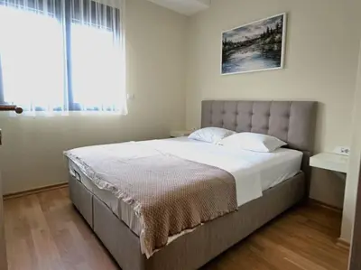 a large bed in a bedroom with a large window at The Serendipity in Podgorica