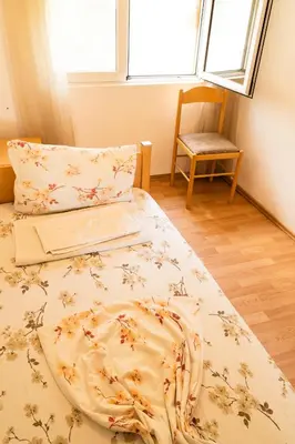 a bedroom with a bed and a chair and a window at Solaris Summer Resort Apartments in Sutomore