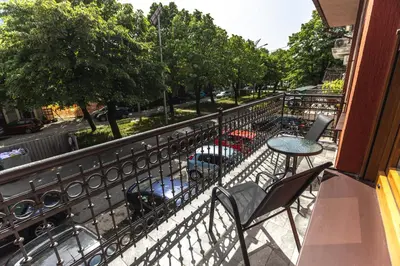 a balcony with a table and chairs on a street at Apartmani Bulevar in Cetinje