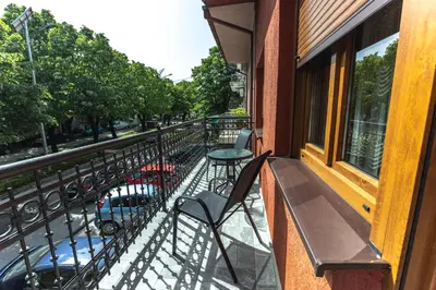 a balcony with a table and chairs on a street at Apartmani Bulevar in Cetinje