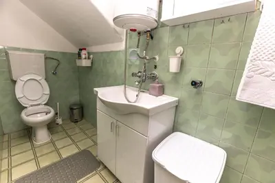 a small bathroom with a toilet and a sink at Apartmani Bulevar in Cetinje