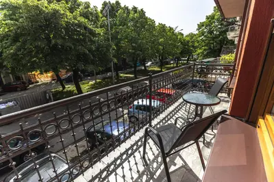 a balcony with a table and chairs on a street at Apartmani Bulevar in Cetinje