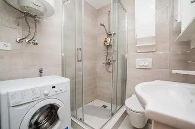 a bathroom with a washing machine and a shower at Pizana Budva Central in Budva