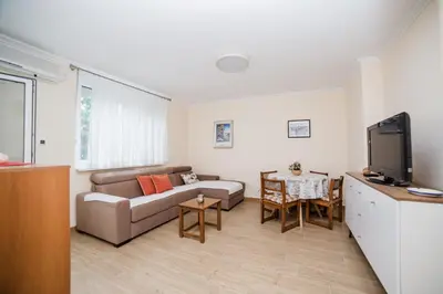 a living room with a couch and a tv at Pizana Budva Central in Budva