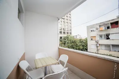 a room with a table and chairs on a balcony at Pizana Budva Central in Budva