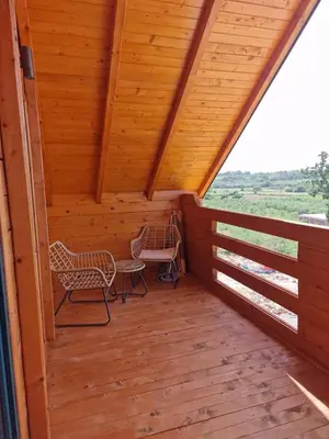 a screened porch with two chairs and a table at Bungalovi Spahic in Ulcinj