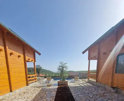 a large wooden building with a patio and a pool at Bungalovi Spahic in Ulcinj