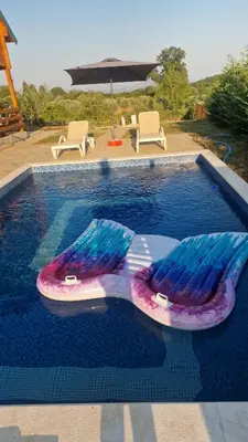 a swimming pool with two lounge chairs and an umbrella at Bungalovi Spahic in Ulcinj