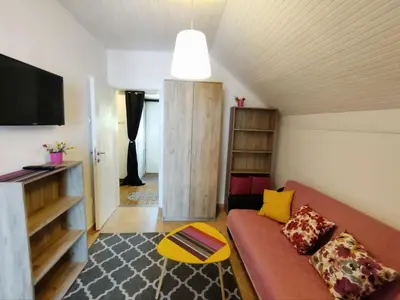 a living room with a couch and a tv at Арartment IRENA in Dobra Voda