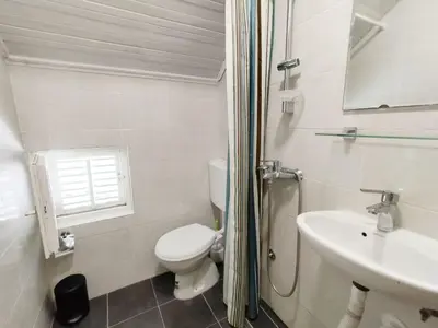 a white bathroom with a toilet and a sink at Арartment IRENA in Dobra Voda