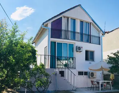 a white house with a table in front of it at Арartment IRENA in Dobra Voda