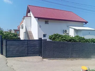 a fence in front of a house with a red roof at Арartment IRENA in Dobra Voda