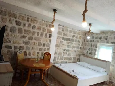 a bedroom with a bed and a table in a room at Luiggi in Kotor