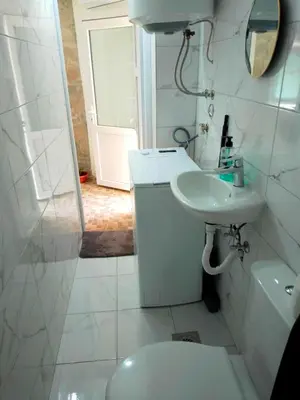 a white bathroom with a sink and a toilet at Luiggi in Kotor