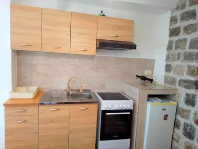 a small kitchen with a sink and a stove at Luiggi in Kotor