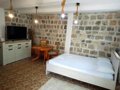 a bedroom with a bed and a table with a tv at Luiggi in Kotor