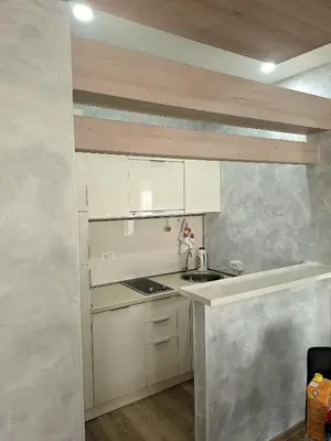a small kitchen with white cabinets and a sink at Apartment AS in Ulcinj
