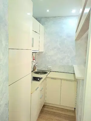 a white kitchen with white cabinets and a sink at Apartment AS in Ulcinj