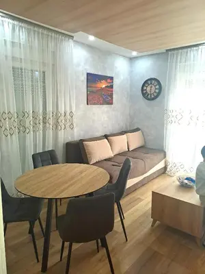 a living room with a couch and a table with chairs at Apartment AS in Ulcinj