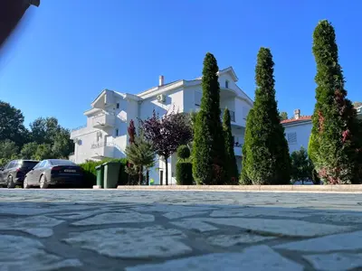 a large white building with trees in front of it at Residence LEORA in Ulcinj