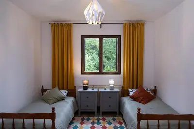 a room with two beds and a window with yellow curtains at Villa Concordia in Budva