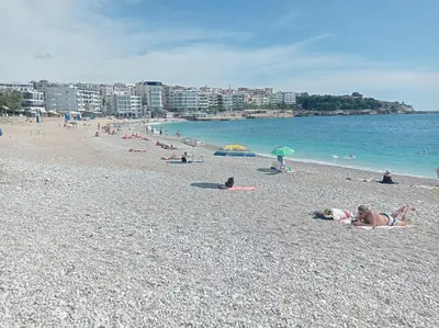 a group of people laying on a beach at Olga 112 in Bar