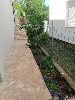 a garden with a stone walkway next to a house at Olga 112 in Bar