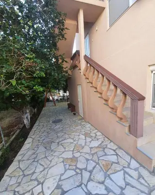 a house with a staircase and a stone walkway at Aleksandrija in Čanj