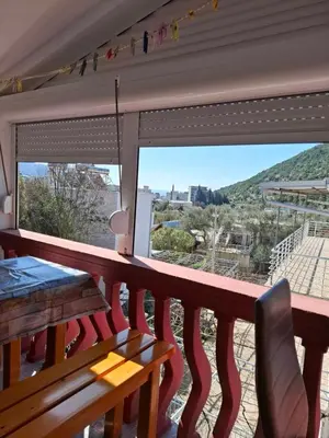 a balcony with a table and a view of a mountain at Aleksandrija in Čanj