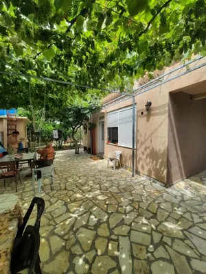 a stone patio with a table and chairs at Aleksandrija in Čanj