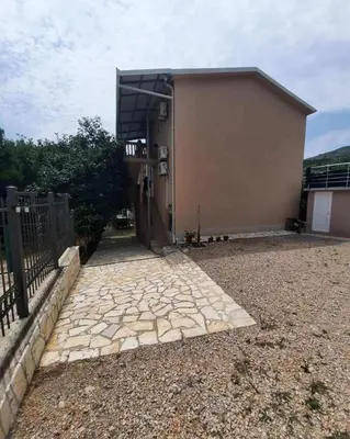 a building with a stone walkway in front of it at Aleksandrija in Čanj