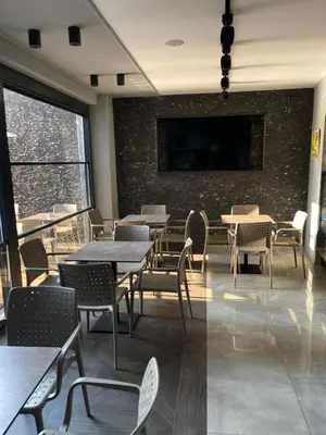 a dining room with tables and chairs and a flat screen tv at Viola Hotel Budva in Budva