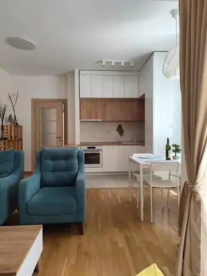 a living room with a blue chair and a table at Kan in Podgorica