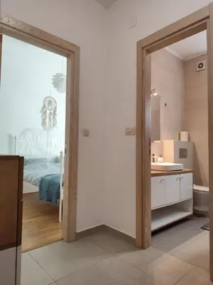 a bathroom with a door leading to a bedroom at Kan in Podgorica