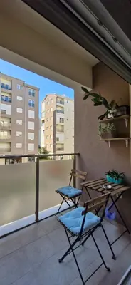 two chairs and a table on a balcony with buildings at Kan in Podgorica