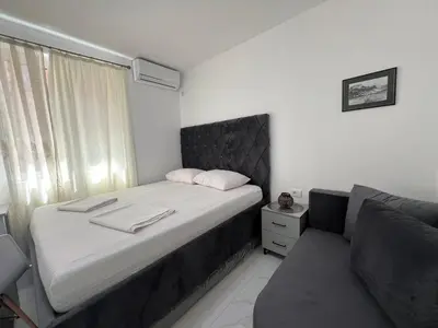 a small bedroom with a bed and a couch at Kontiki Apartments 2 in Ulcinj