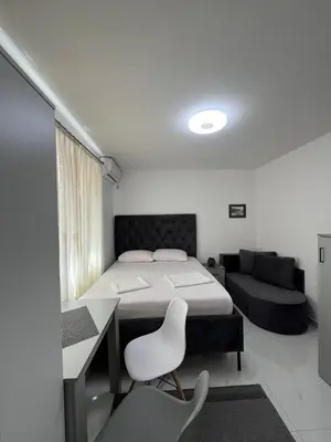 a bedroom with a bed and a desk and a couch at Kontiki Apartments 2 in Ulcinj