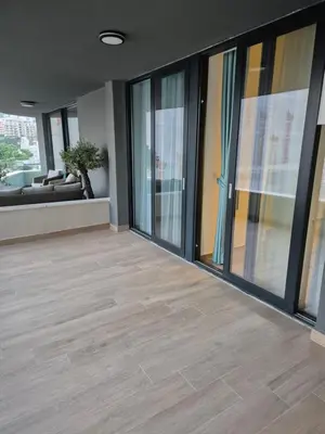 an empty lobby with glass doors and a couch at Rafailovici Beachfront Apartment 2 in Budva