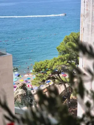 a view of a beach with people in the water at Rafailovici Beachfront Apartment 2 in Budva