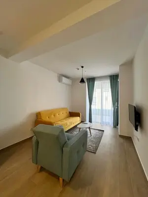 a living room with a couch and a chair at Rafailovici Beachfront Apartment 2 in Budva