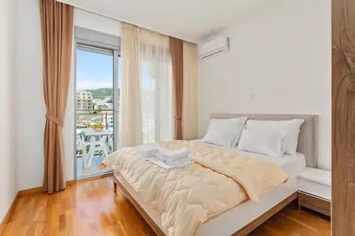 a bedroom with a large bed with a large window at ID LUX APARTMENTS in Becici