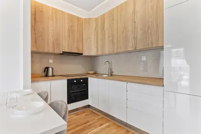 a kitchen with white cabinets and a table with a sink at ID LUX APARTMENTS in Becici