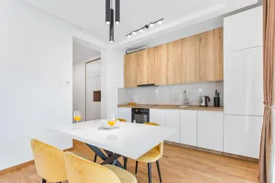 a kitchen and dining room with a white table and chairs at ID LUX APARTMENTS in Becici