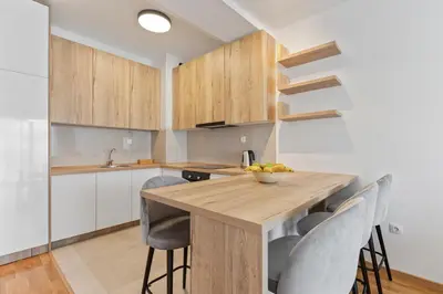 a kitchen with a wooden table and chairs at ID LUX APARTMENTS in Becici